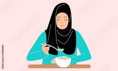 Muslim woman wearing a hijab and traditional arabian clothes having breakfast, lunch or dinner