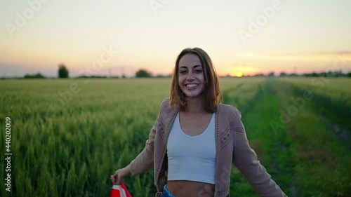 Happy young woman holding usa United States flag outdoor after sunset with polica lights on face. photo