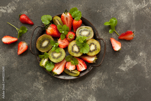 bright and fresh strawberries and kiwi on a dark background © lokisurina