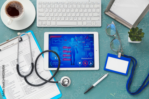 Tablet computer with stethoscope and laboratory test form on color background