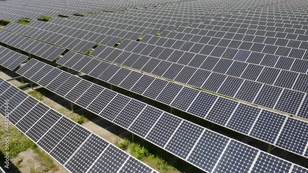 Thousands of Photovoltaic Cells Producing Renewable Energy from the Sunlight during Daytime. Low Aerial Dolly over Solar Panels Thousands of Photovoltaic Cells Producing Renewable Energy from the Sunlight during Daytime. Low Aerial Dolly over Solar Panels