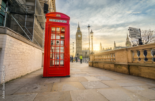 Red telephone booth and Big Ben at sunrise in London. England