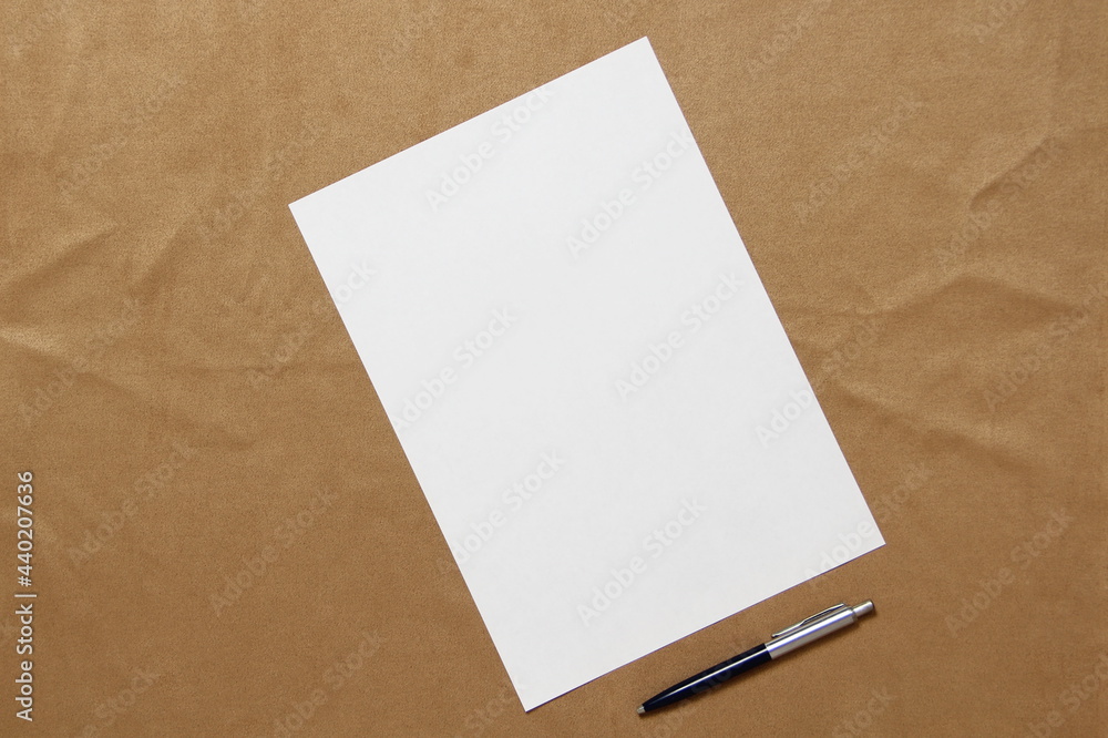 Template of white paper with pen lies diagonally on light brown cloth background. Concept of business plan and strategy. Stock photo with empty space for text and design. - obrazy, fototapety, plakaty 