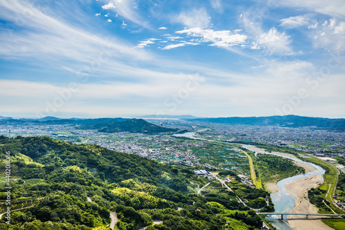 梅雨晴れの中、紀の川上空を飛ぶパラグライダーから和歌山市街と和歌山湾を望む