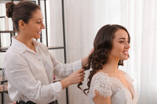 Stylist working with client in salon  making wedding hairstyle