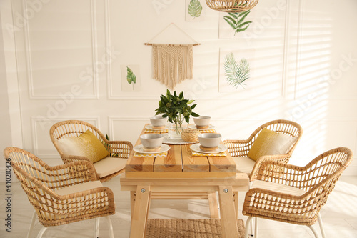 Stylish wooden dining table and chairs in room. Interior design photo