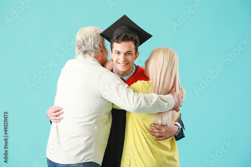 Wallpaper Mural Happy male graduation student with his parents on color background Torontodigital.ca