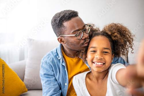 Family is the most important thing. Self portrait of young father and his little daughter smiling. Smiling father with little cute preschool daughter looking at smartphone screen taking making selfie