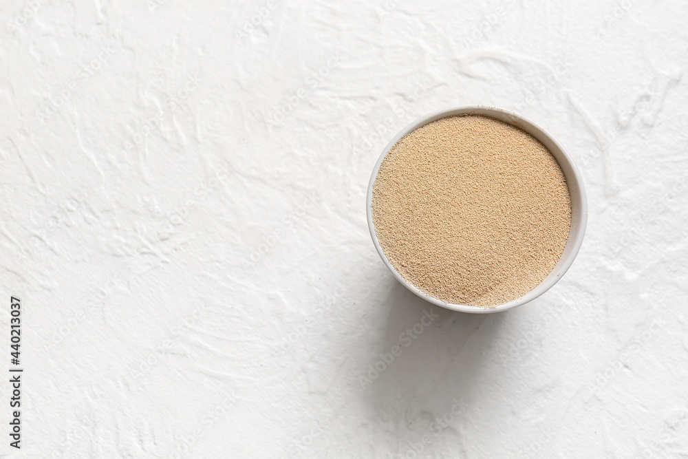 Bowl with active dry yeast on light background Bowl with active dry yeast on light background
