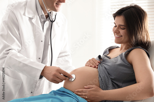 Doctor examining woman before giving child birth in maternity hospital, closeup photo