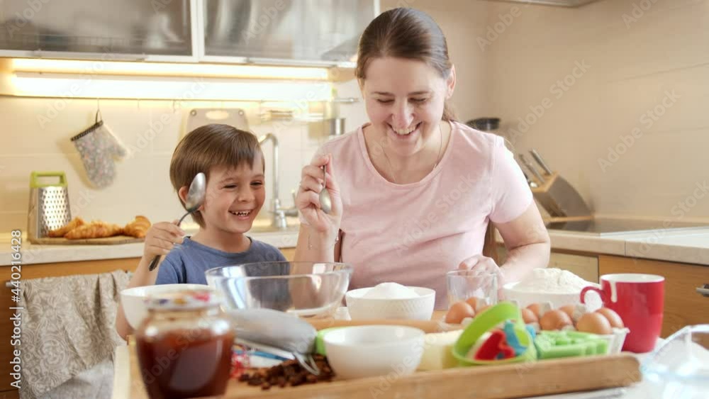 Little boy with mother looking on ingredients for cooking tasty dish. Children cooking with parents, little chef, family having time together, domestic kitchen. Little boy with mother looking on ingredients for cooking tasty dish. Children cooking with parents, little chef, family having time together, domestic kitchen.