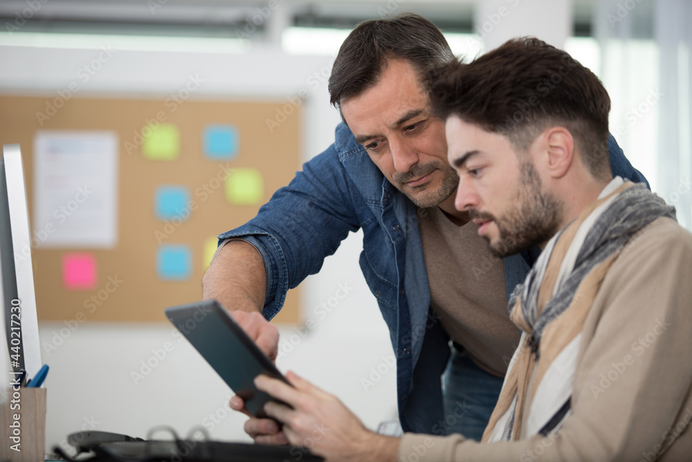 professor helping student using a tablet professor helping student using a tablet
