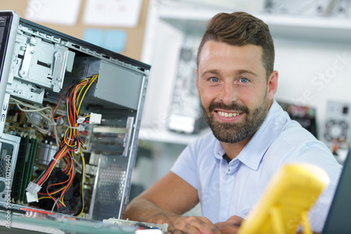 smiling young electronics technician at work