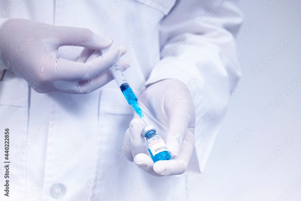 Obraz premium Doctor holds syringe and coronavirus vaccine bottle,concept of corona virus treatment