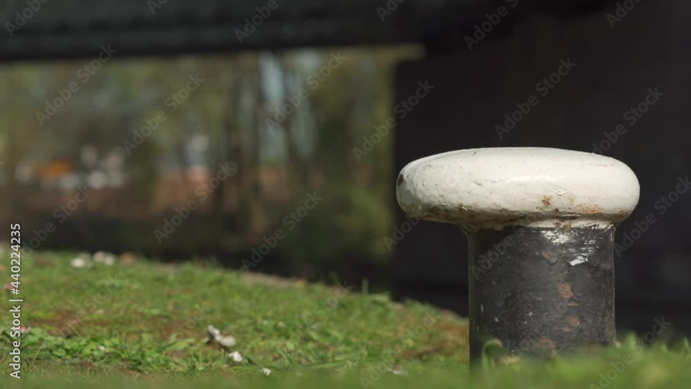 A canal anchor post for narrowboats with shallow depth of field, wild bird and bridge background A canal anchor post for narrowboats with shallow depth of field, wild bird and bridge background