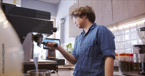 Asian non-binary owner happily making espresso shot for a customer in own coffee shop. Slow Motion - Authentic LGTBQ+ inclusive moments in community and local business, pride month concept.