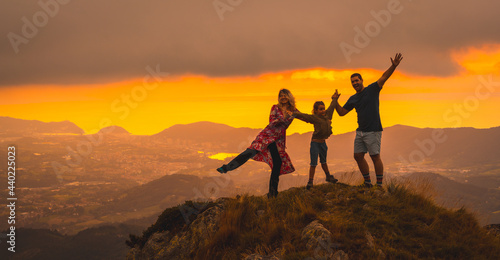 Mother and father next to his son in a beautiful sunset in the mountain. Adventure lifestyle A summer afternoon in the mountains of the Basque country