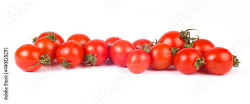 long row of juicy ripe red cherry tomatoes on white background