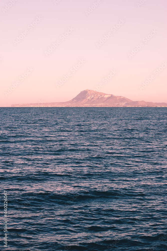 Mountain peak seen from seaport over dark blue sea waves