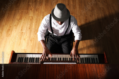 Obraz na plátne African-American man playing piano indoors, above view