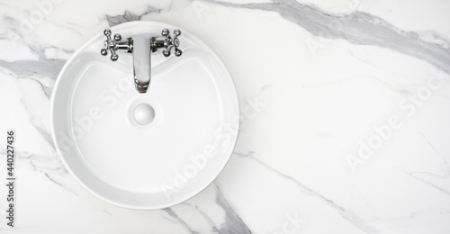 Round bathroom washing sink on marble stone surface, top view photo