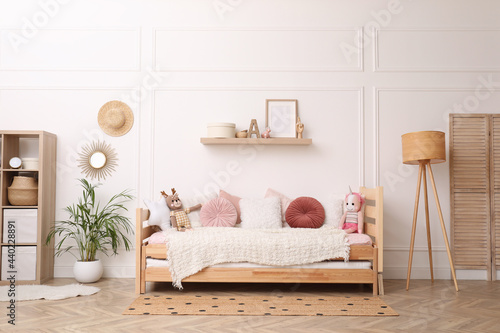 Photography Cute child's room interior with comfortable bed and toys