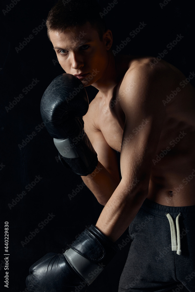 boxer leaned forward on black background with gloves 