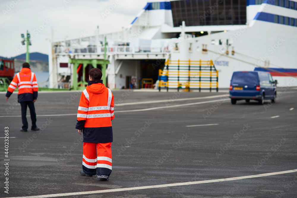 staff regulating the disembarkation of vehicles in the ferry in the port of Bilbao staff regulating the disembarkation of vehicles in the ferry in the port of Bilbao