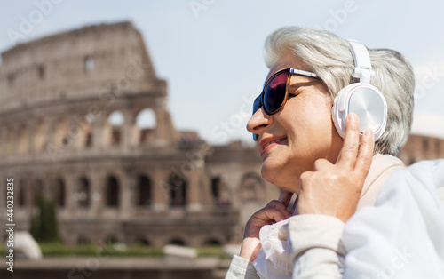 Photography technology, old people and travel concept - senior woman in headphones and sungl
