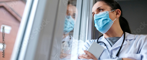 Self confident female doctor looking out the hospital window