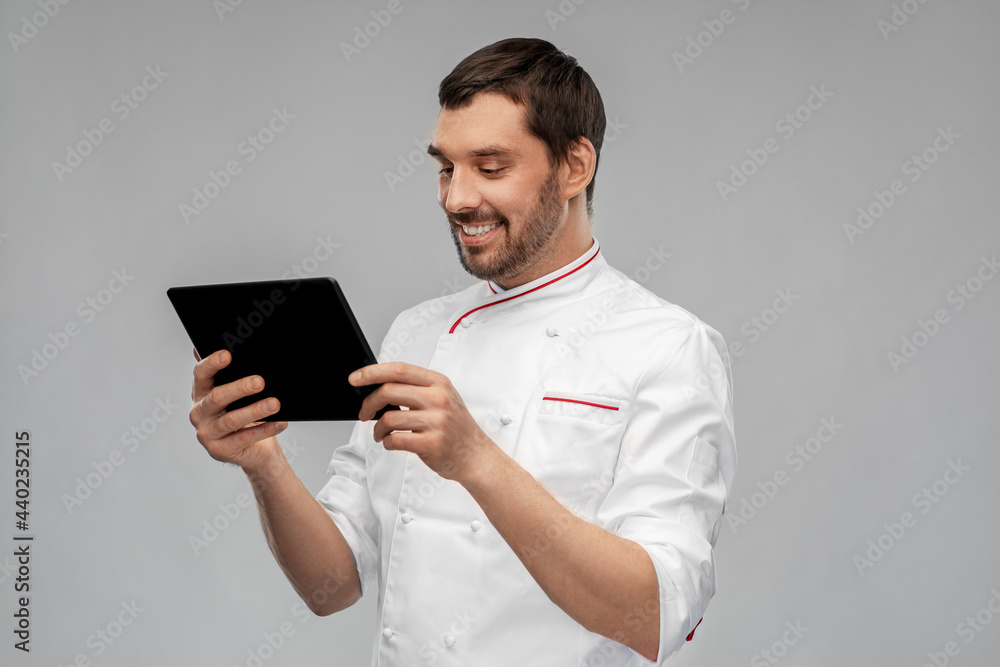 cooking, culinary and people concept - happy smiling male chef with tablet pc computer over grey background cooking, culinary and people concept - happy smiling male chef with tablet pc computer over grey background