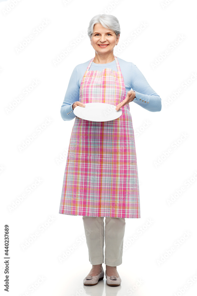 cooking, culinary and old people concept - portrait of smiling senior woman in kitchen apron with empty plate over white background cooking, culinary and old people concept - portrait of smiling senior woman in kitchen apron with empty plate over white background