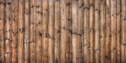 Wooden planks fence. It made of wood lumbers or timbers.