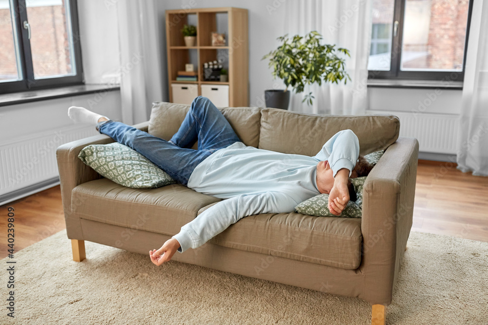people, boredom and depression concept - bored or lazy young man lying on sofa at home people, boredom and depression concept - bored or lazy young man lying on sofa at home