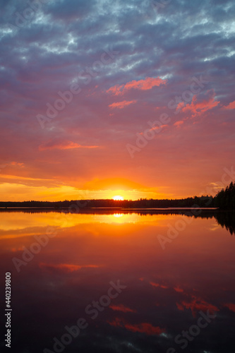 Scenic and beautiful sunset and colorful cloudy sky and their reflections on a lake in Finland at summer. © tuomaslehtinen