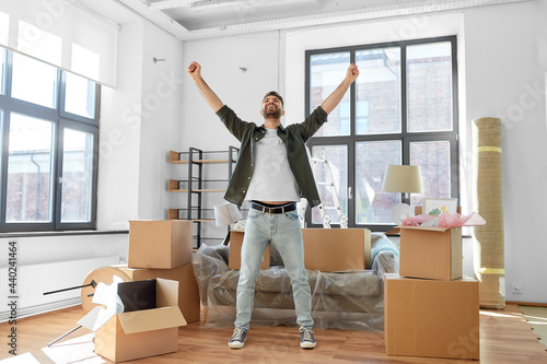 moving, people and real estate concept - happy smiling man with boxes at new home