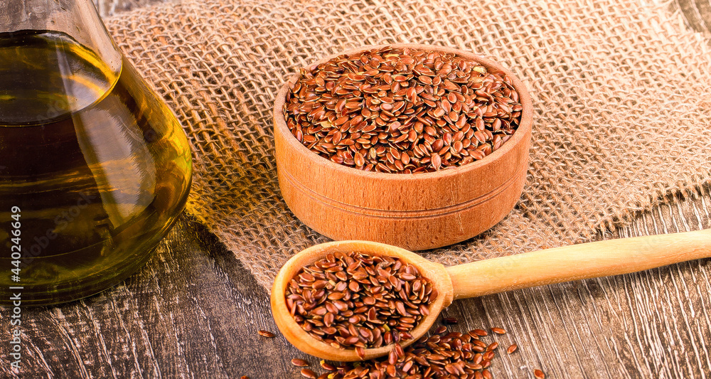 Brown flax seeds and flaxseed oil on a wooden surface Brown flax seeds and flaxseed oil on a wooden surface