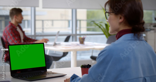 Young businesswoman sitting at desk and working in office