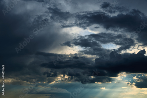 beautiful dark dramatic sky with sunlight and clouds as a background