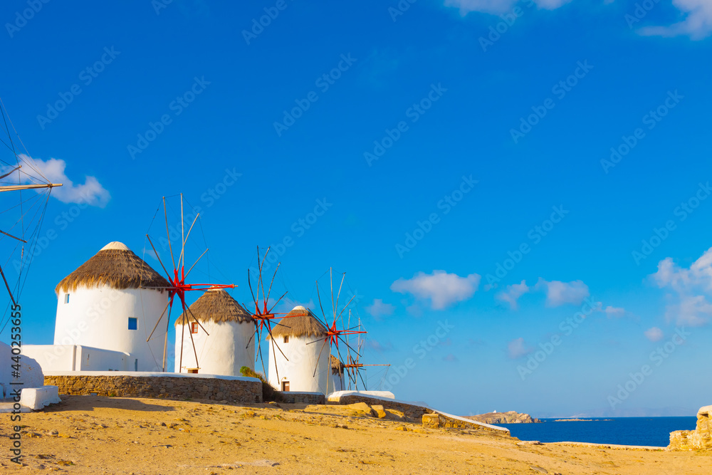 Naklejka premium Windmills with blue sky and clouds in Mykonos island cyclades Greece