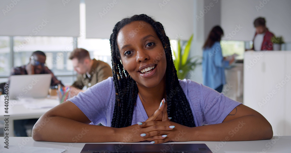 Fototapeta premium Cheerful young black woman having video call on laptop at office