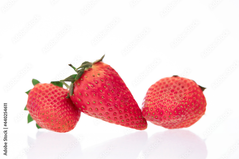 Red ripe strawberries shot against a white background with balsamic vinegar, chocolate being drizzled over Red ripe strawberries shot against a white background with balsamic vinegar, chocolate being drizzled over