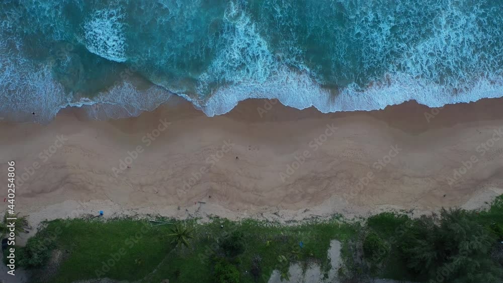aerial top view sea waves seamless loop on the white Phuket sand beach. .Wave after wave swept towards the shore at sunset. . blue sea, and clear sand landscape. Paradise beach. aerial top view sea waves seamless loop on the white Phuket sand beach. .Wave after wave swept towards the shore at sunset. . blue sea, and clear sand landscape. Paradise beach.