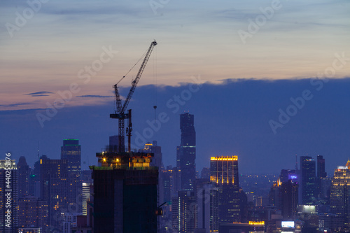 hight crane work on hight building in the city on twilight sky sunset evening 