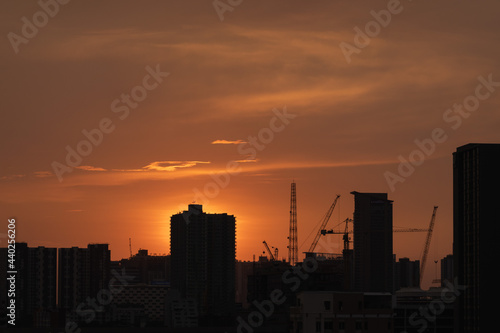 sunset over the city skyscape crane on building