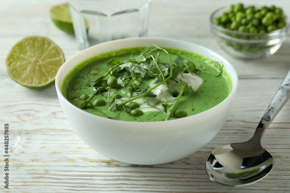 Concept of tasty eating with pea soup on white wooden table Concept of tasty eating with pea soup on white wooden table