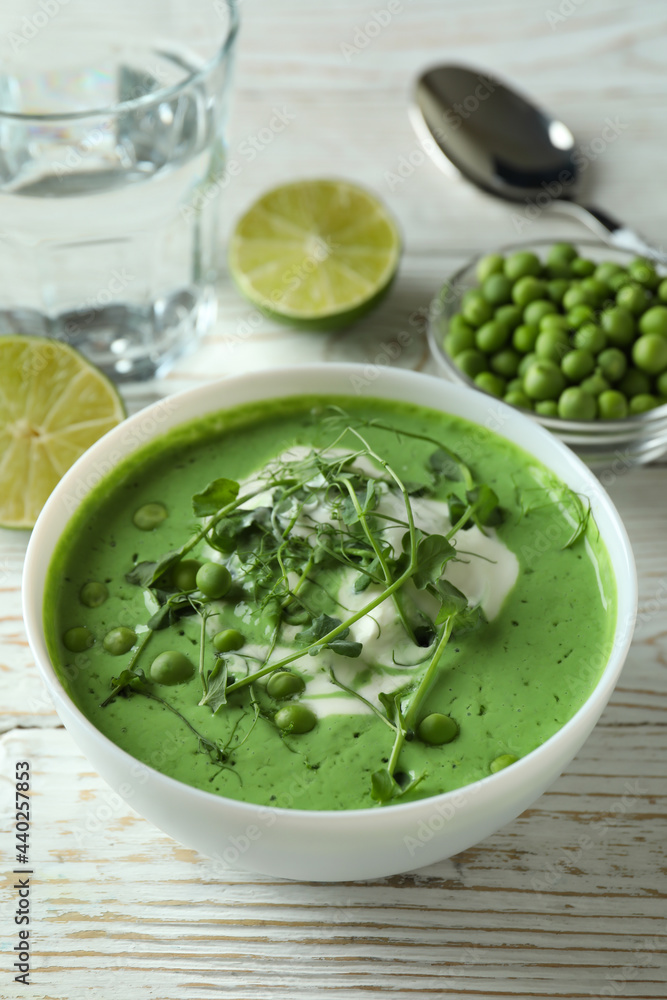 Concept of tasty eating with pea soup on white wooden table Concept of tasty eating with pea soup on white wooden table