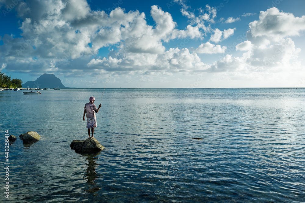 Junges Mädchen angelt auf einem Felsen - Mauritius