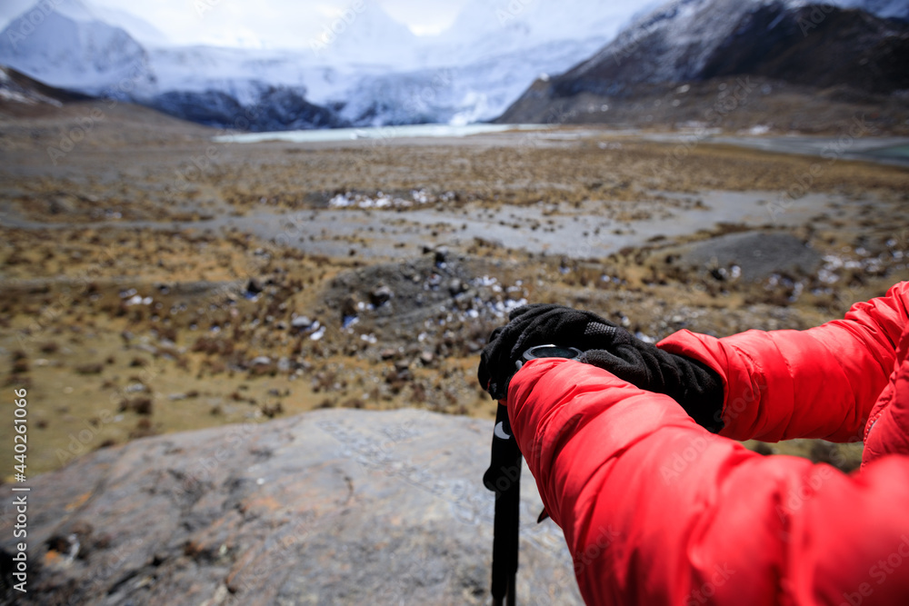 Woman hiker checking the altimeter on sportswatch in winter tibet