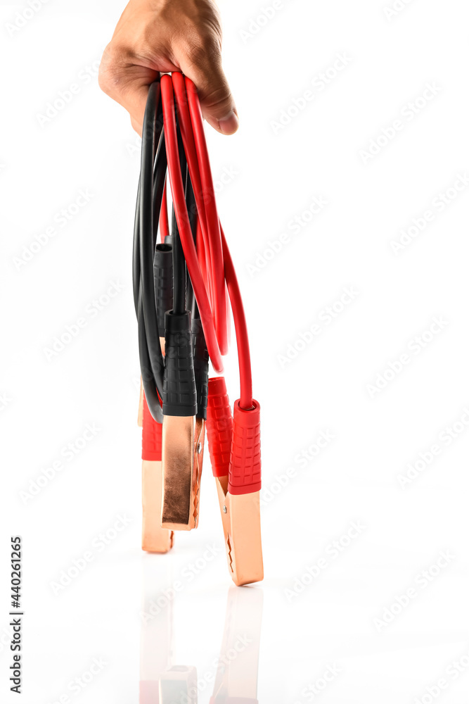 Man hand holding black and red battery extension cable for vehicle isolated on white background, emergency device in car Man hand holding black and red battery extension cable for vehicle isolated on white background, emergency device in car